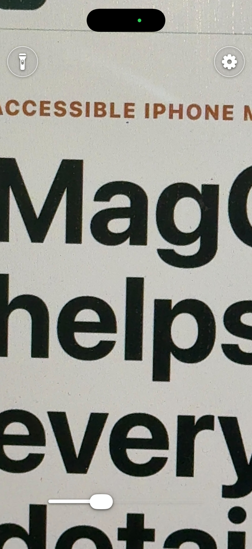 MagGlass enlarging printed text on a phone screen.
